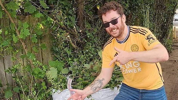 Alex Lock for Lloyds and Corby Villages Alex Lock pointing at cleaned up green waste